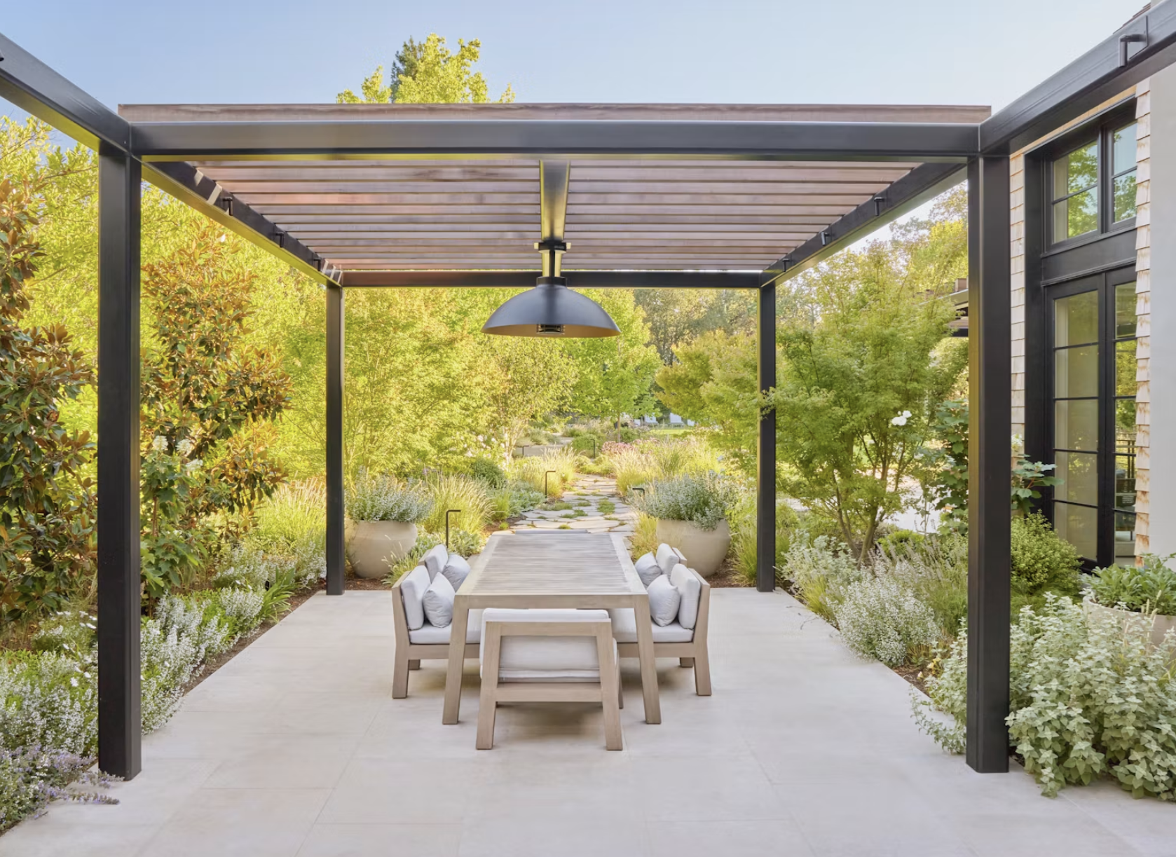 Outdoor dining space framed by a garden pergola