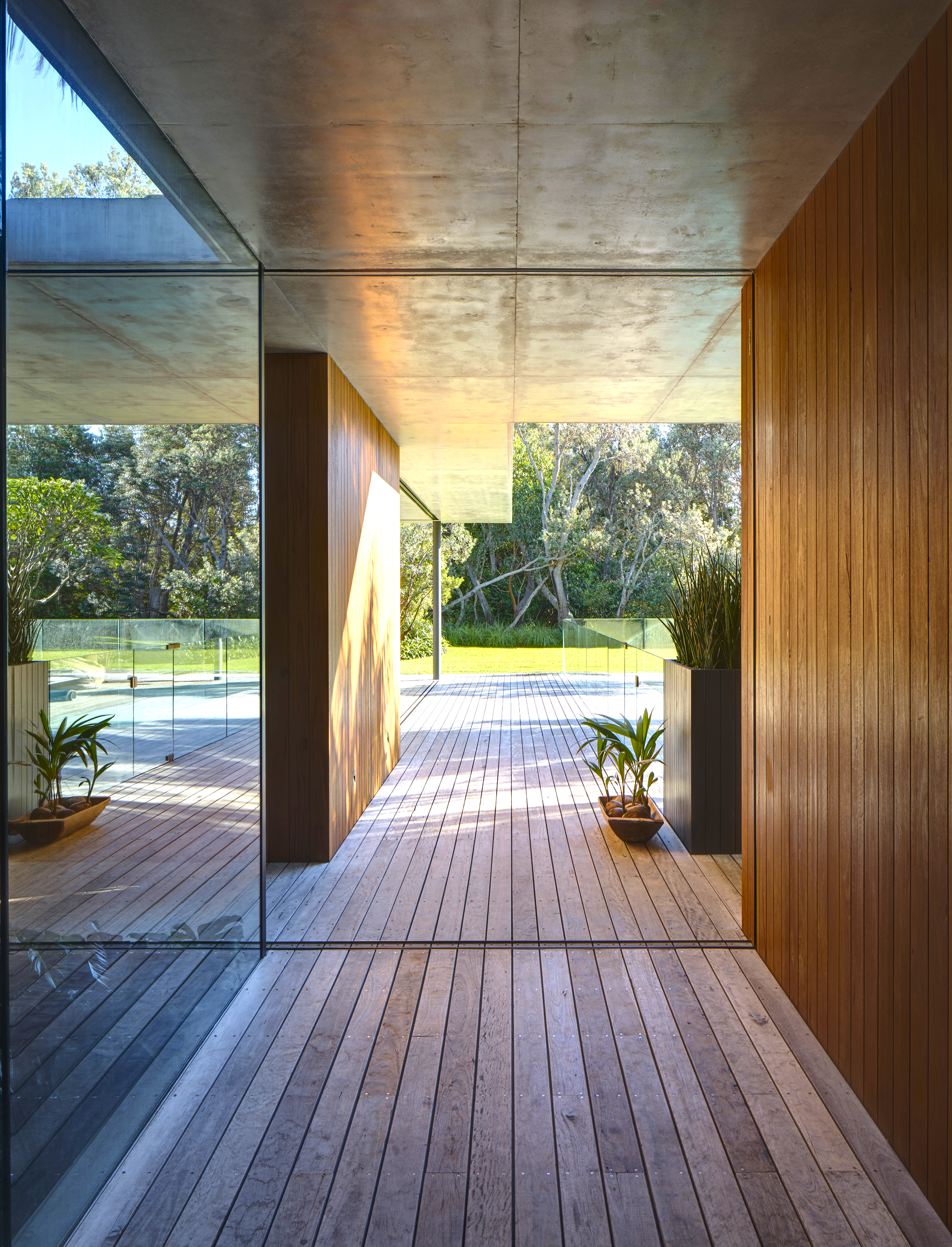 Timber-lined passage opening onto a landscaped pool